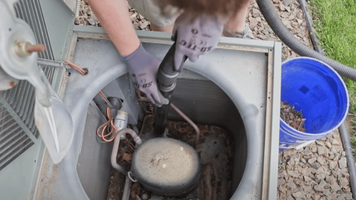 Removing the top of an air conditioning condenser unit for cleaning