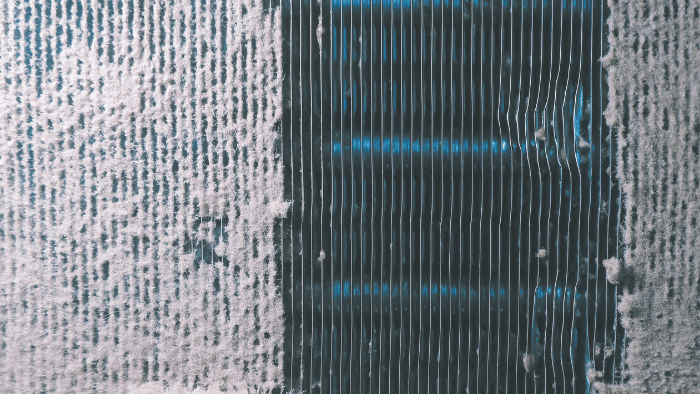 Using a flashlight to check the cleanliness of air conditioner condenser fins